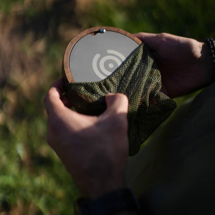 دم افزار اسپرو (Sprew) تصویری نزدیک از دو دست که در حال بیرون آوردن دم افزار اسپرو از توری قابل حمل آن در طبیعت