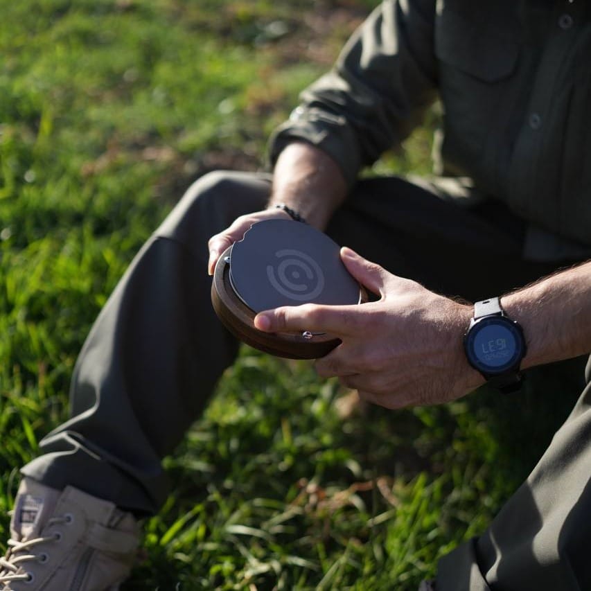 دم افزار اسپرو (Sprew) فردی با لباسهای طبیعتگردی روی چمن و دم افزار اسپرو در حالت بسته در دست